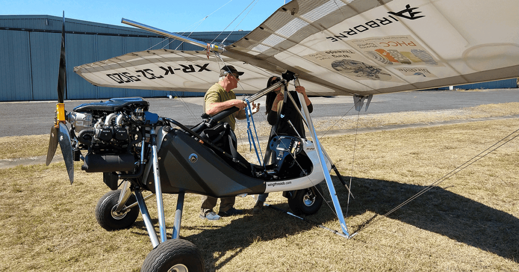 Amellia Formby and Neil Schaeffer attaching a microlight wing to the base